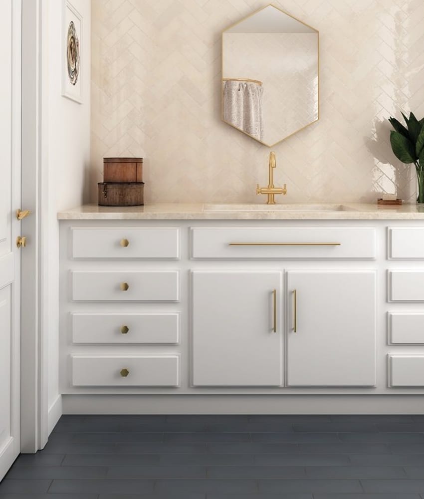 Carrelage Zellige Beige en chevron 6,5X20 sur mur de salle de bain blanc avec vanité blanche et accents dorés