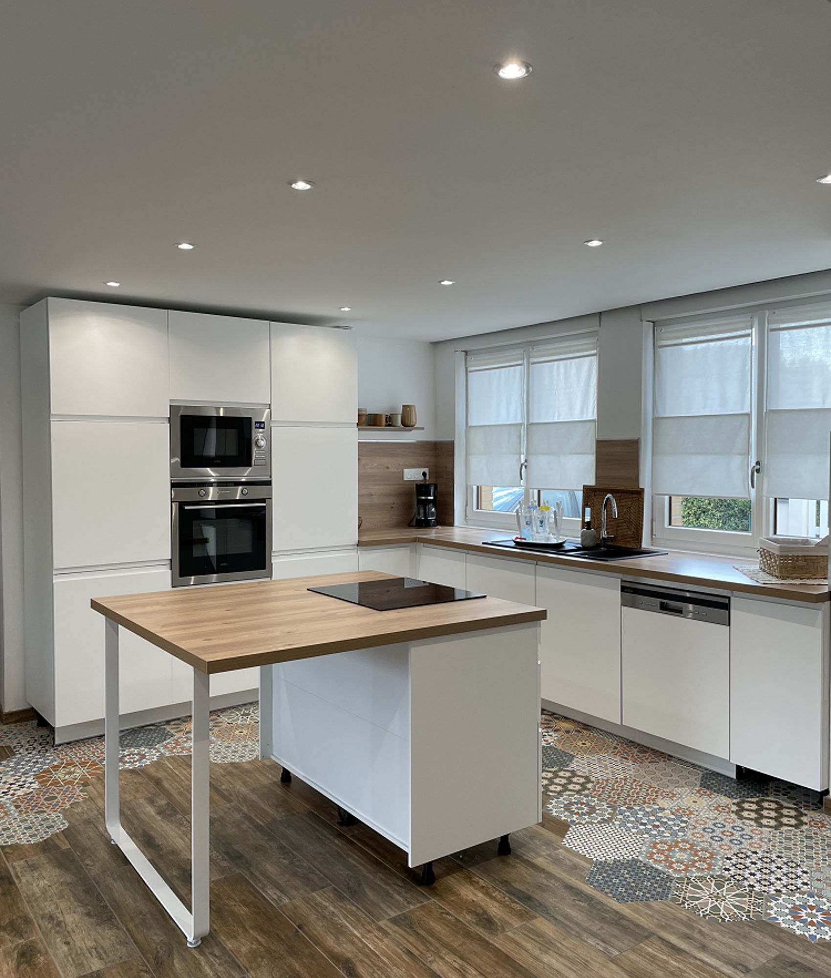 Carreau de ciment terracotta avec motifs colorés 30x30 cm dans une cuisine moderne blanche avec plan de travail en bois et sol e