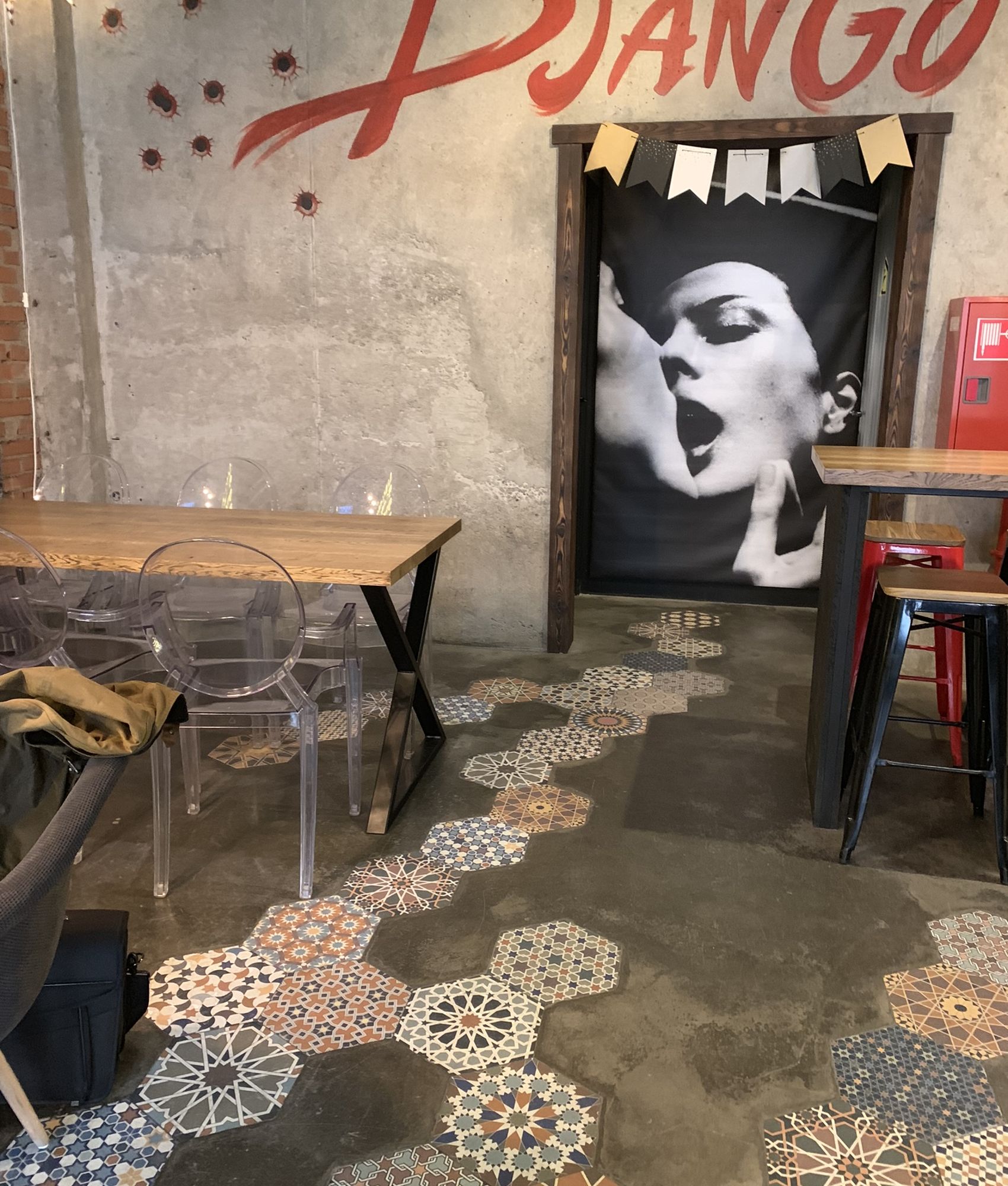 Carreau de ciment terracotta et bleu motifs variés 30x30 cm dans un espace de café avec murs en brique et décor moderne