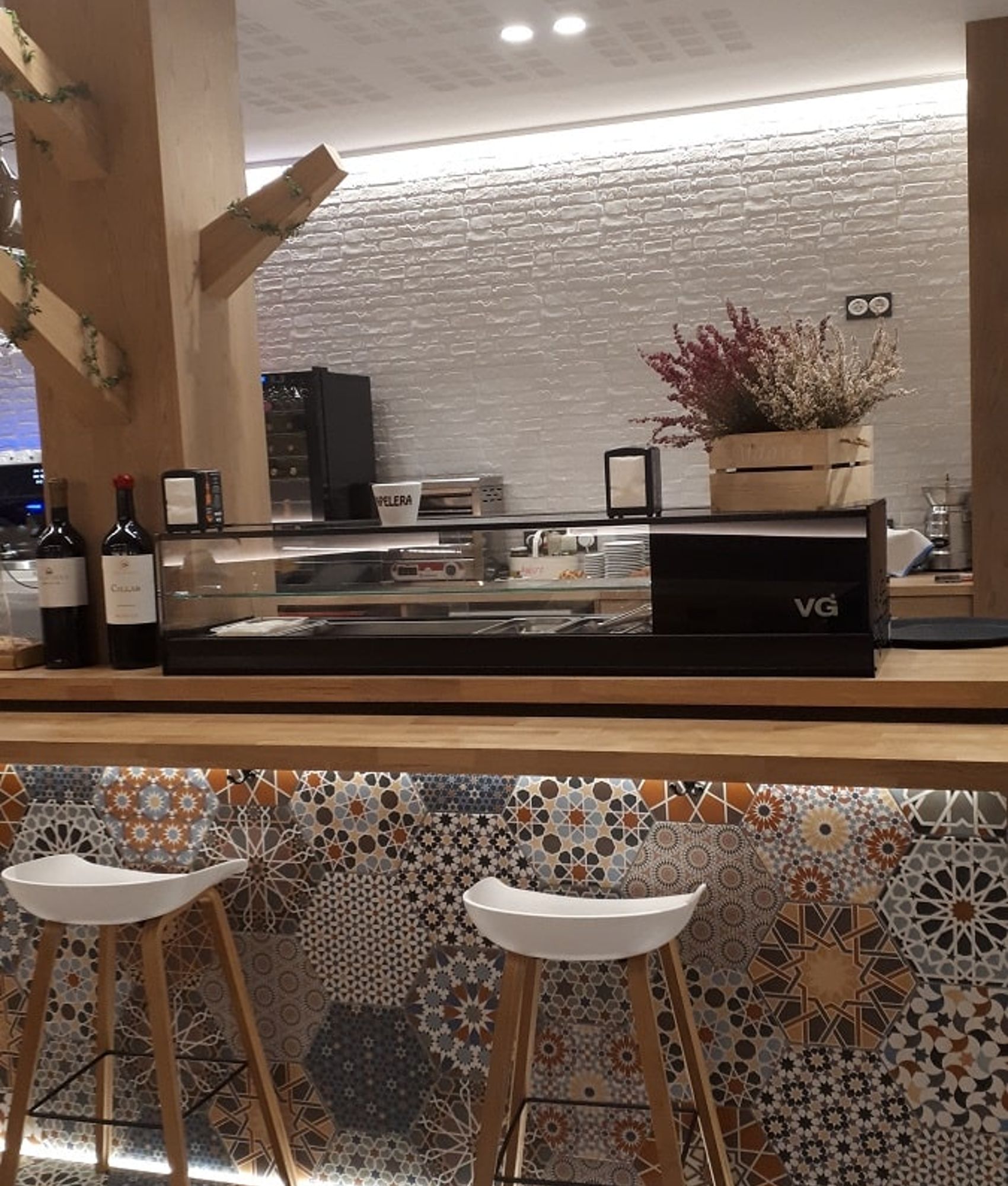 Carreau de ciment terracotta avec motifs floraux et géométriques 30x30 cm dans espace commercial aux murs blancs texture brique 