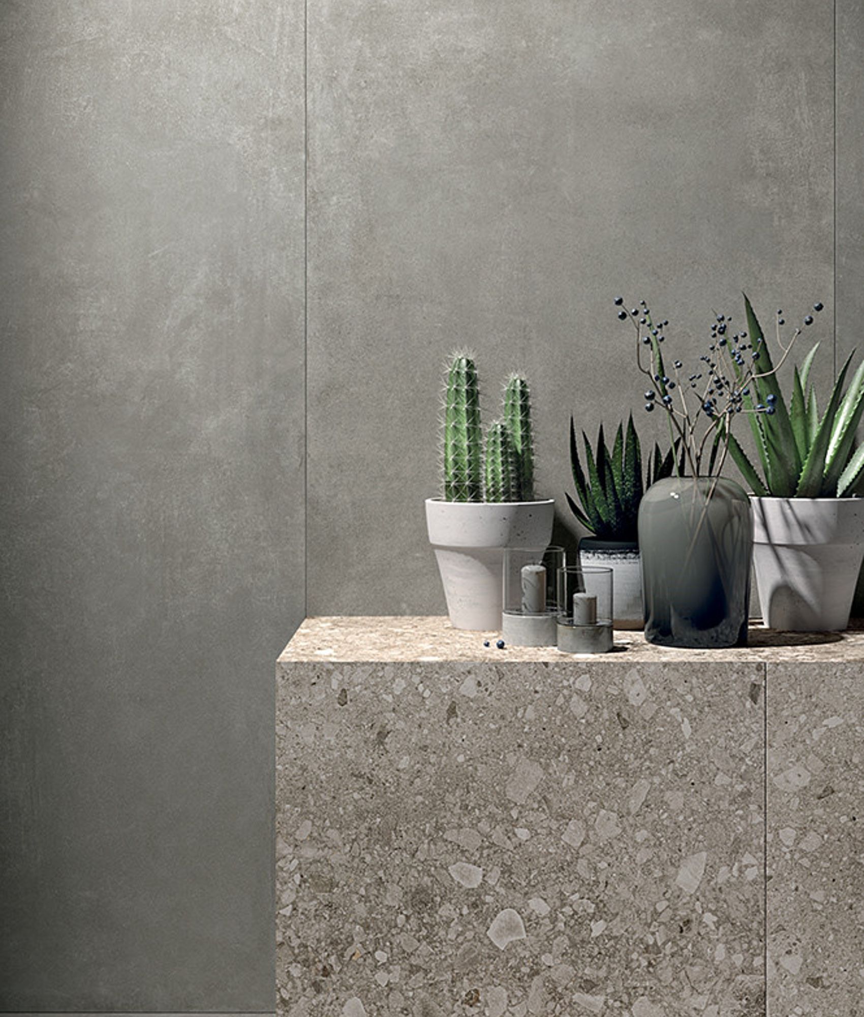 Carrelage effet pierre gris nuancé uni 60x60 cm sur un mur avec comptoir en pierre naturelle et plantes vertes