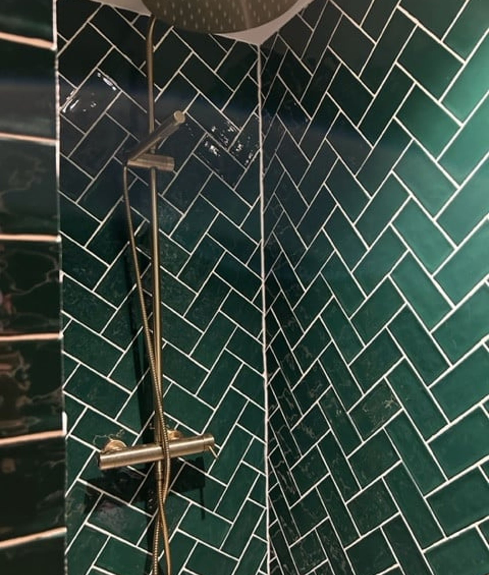 Carrelage uni vert émeraude 7,5x15 cm dans une salle de bain moderne avec des accents de métal chrome et une robinetterie élégan