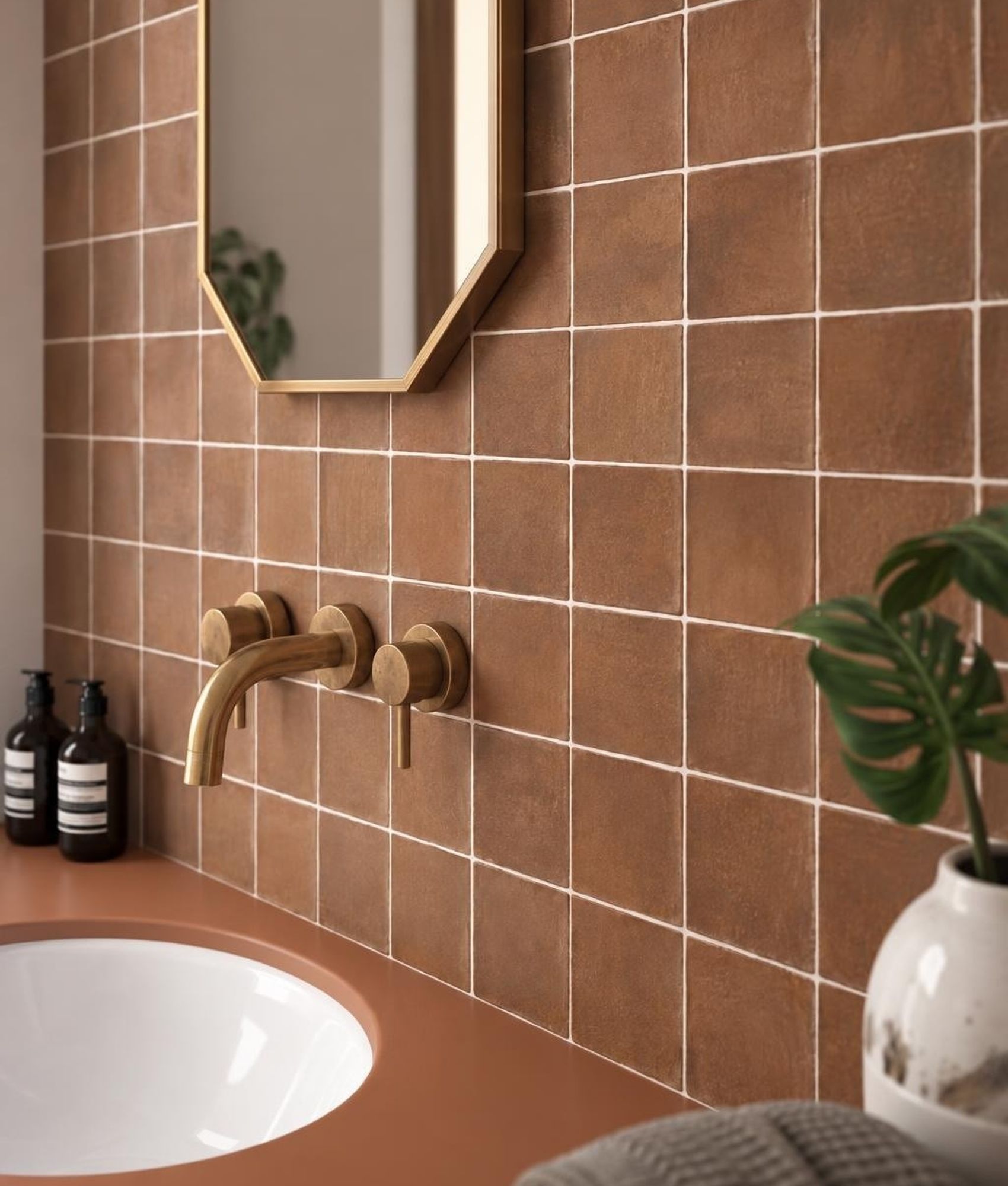 Zellige rouge brillant 10x10 cm sur le mur de la salle de bain tons neutres avec vasque, miroir et luminaire suspendu