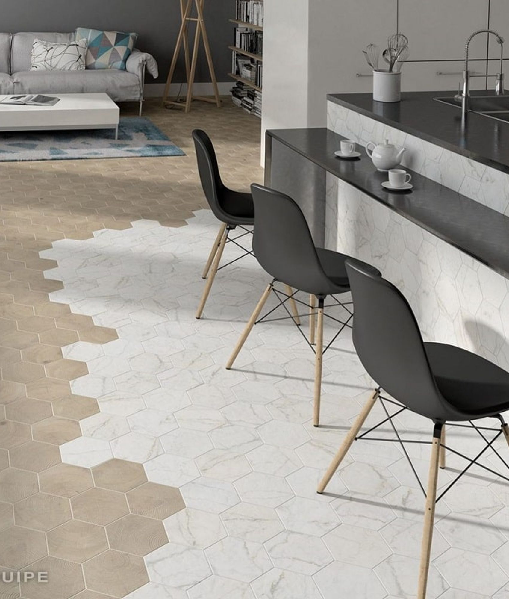 Carrelage marbre blanc hexagonal sur un sol dun salon avec canapé gris, table basse et éléments de cuisine noirs