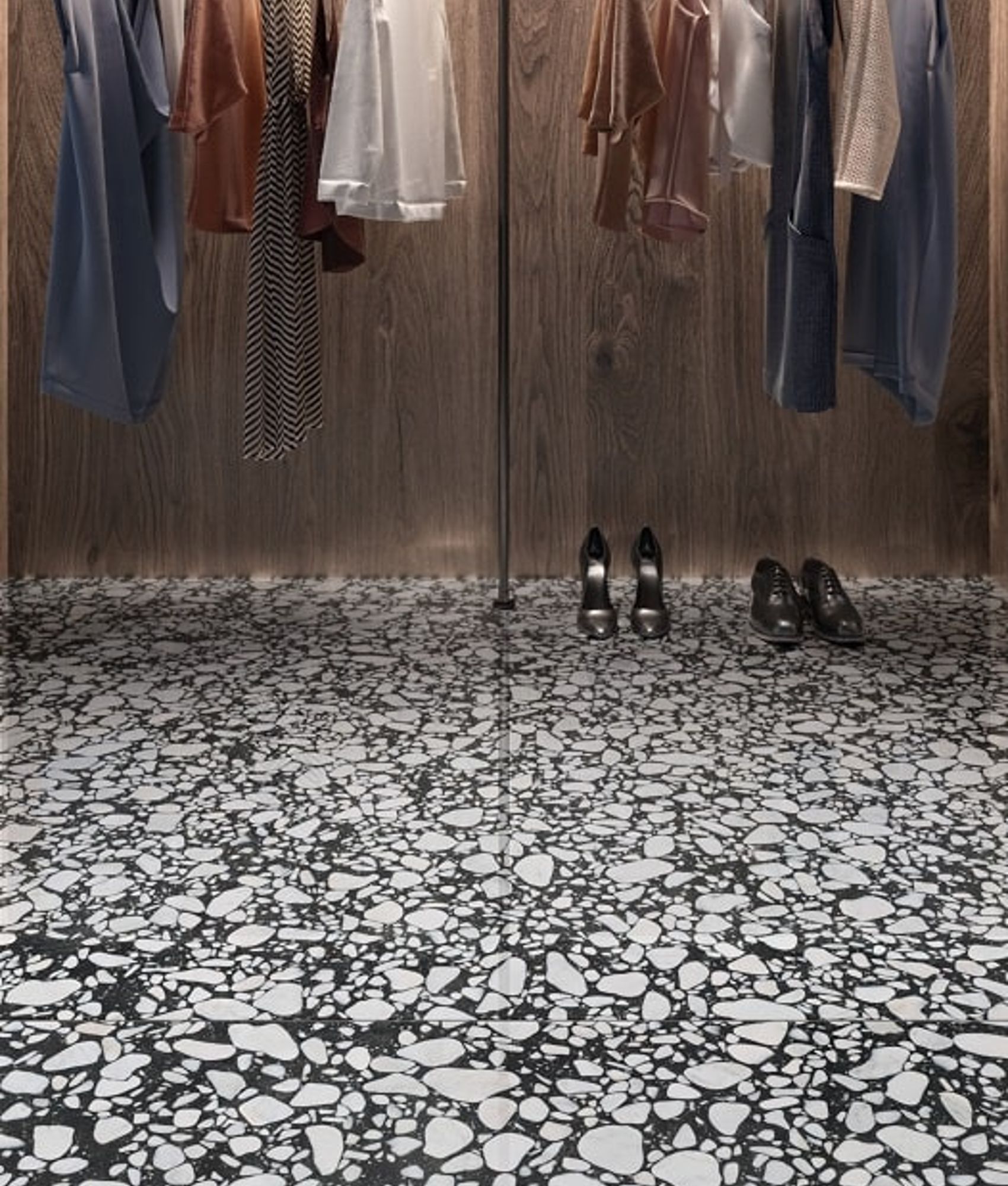 Carrelage Terrazzo noir et blanc 60x60 cm dans un dressing bois et tenues suspendues