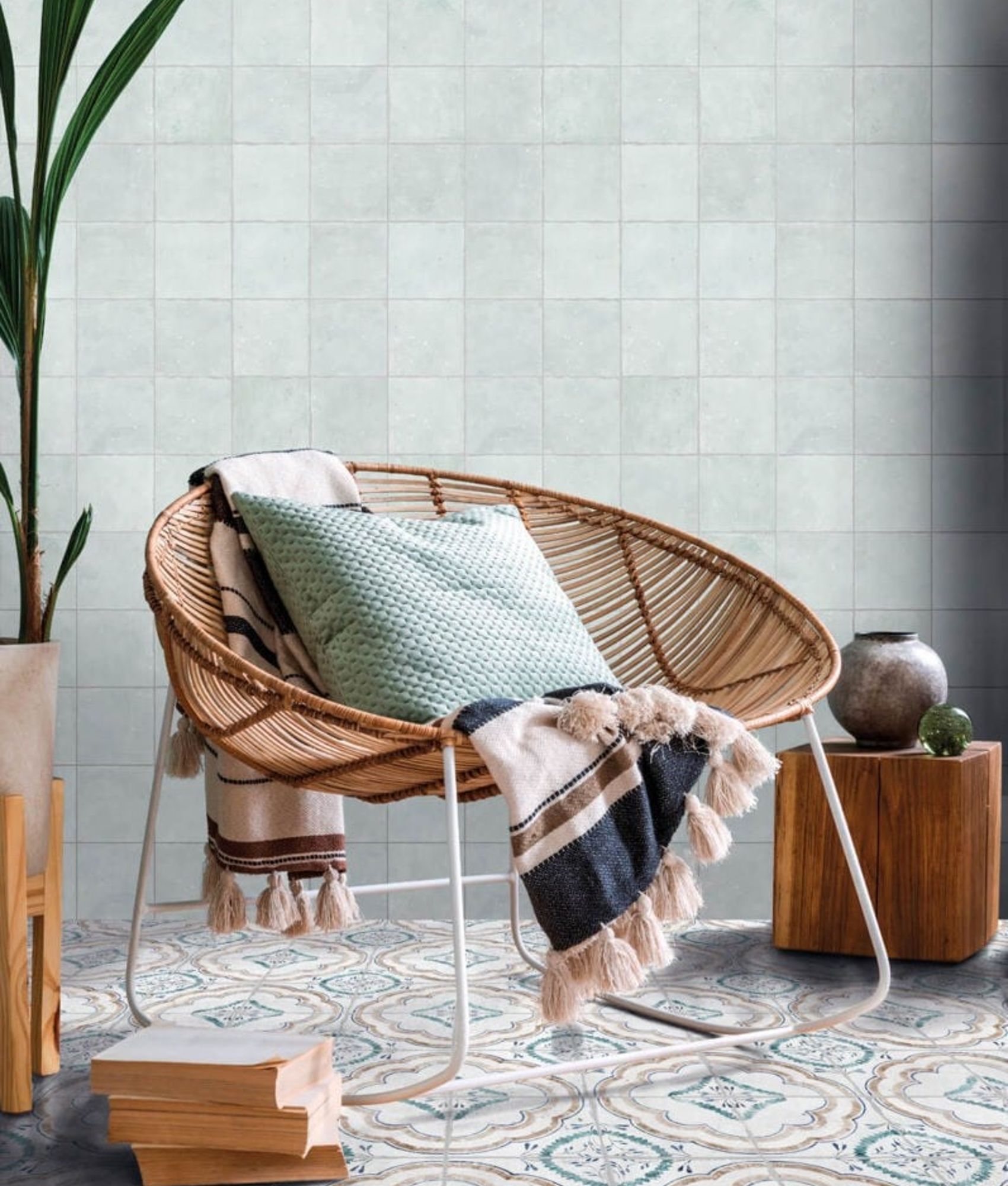 Carreau de ciment multicouleur motifs floraux verts et beiges 15x15 cm dans une pièce tons neutres avec chaise en osier coussins