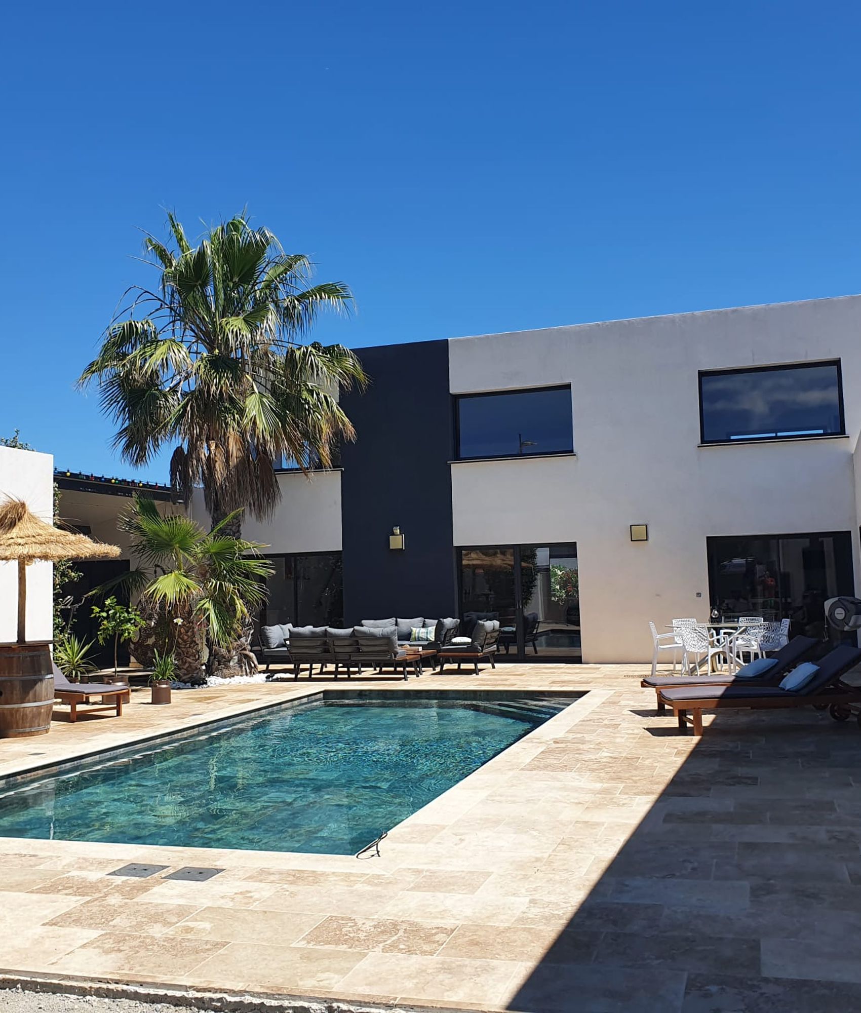 Carrelage aspect pierre couleur terracotta dans un espace extérieur combiné avec une piscine et mobilier de jardin contre une ma